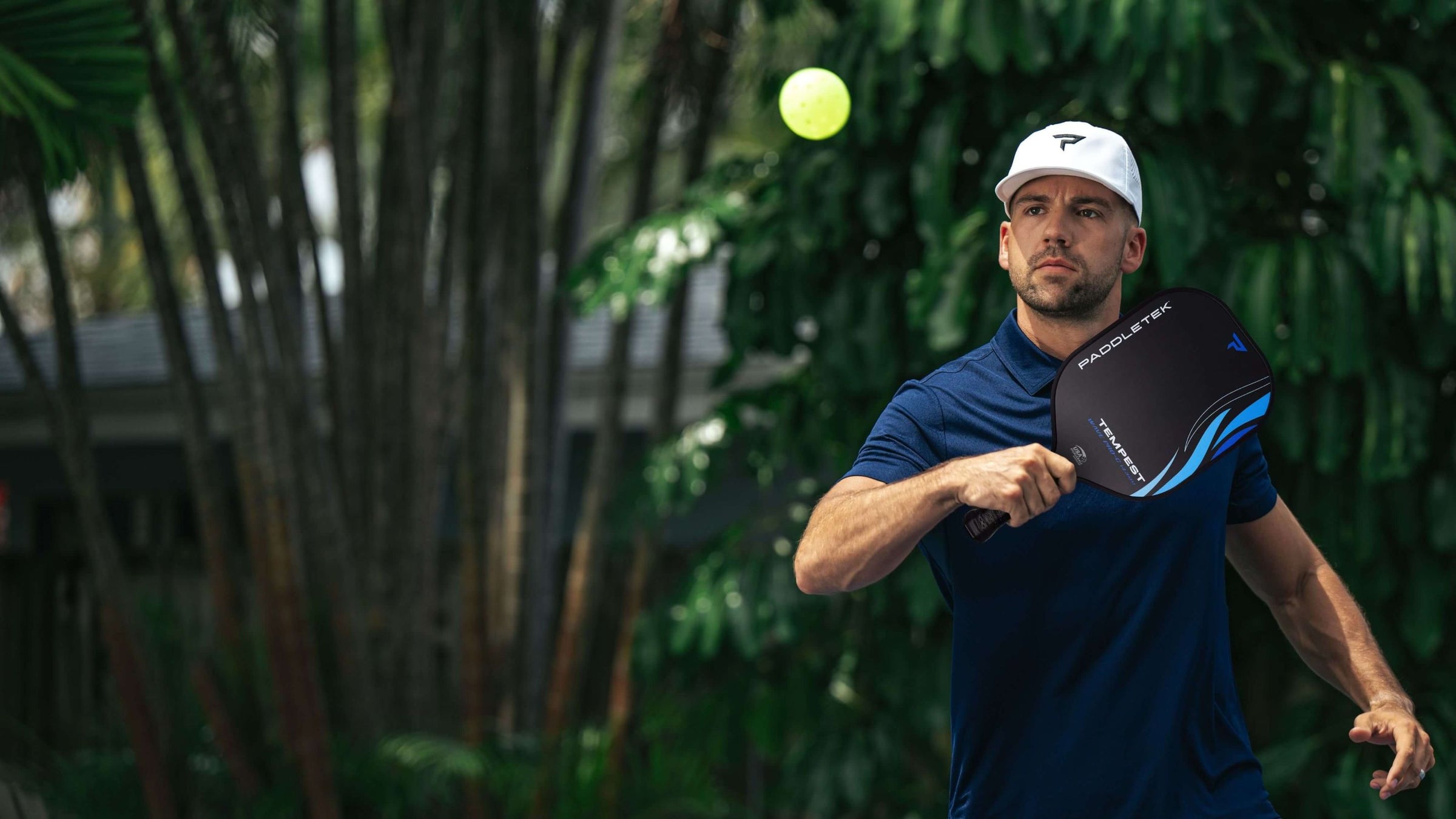 Man plays pickleball outdoors using a Paddletek paddle